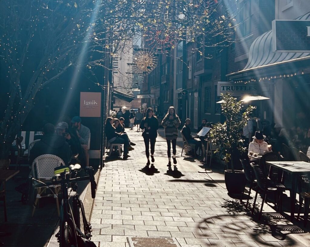 Llankelly place with the sun streaming down and two people walking down the lane.